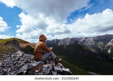 Successful Woman Hiker Using Smart Phone On Alpine Mountain Top