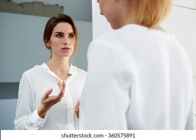 Successful Woman Manager Explaining Something About Work To Her Partner While Standing In Modern Office Interior, Serious Female Proud Ceo Talking With Subordinate After Meeting With Important Clients