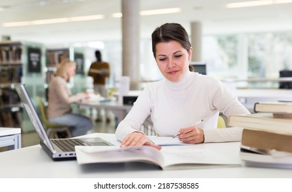 Successful Woman Studying In The Library. High Quality Photo