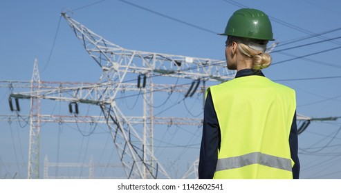 Successful Worker Woman Analyzing Activity And Looking Out At Electricity Pylon Power Wire Lines Network