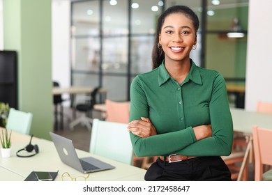 Successful young african-american female entrepreneur, small business owner, female office employee, black businesswoman wearing green casual shirt stands in confident pose with arms crossed - Shutterstock ID 2172458647