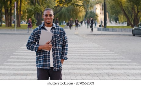 Successful Young Afro American Business Man Guy African Student In Sunglasses Stands In City Street Walking Crosswalk Road Traffic Car Pedestrian Crossing Background Holding Laptop Smiling Going Walks