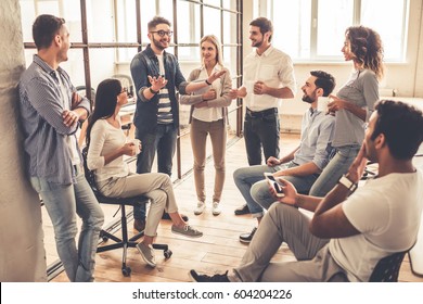 Successful Young Business People Are Talking And Smiling During The Coffee Break In Office