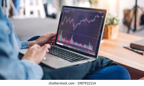 Successful of young business trader asian woman trading graph of stock market investment selling and buying with finance chart data graphs on laptop computer at home