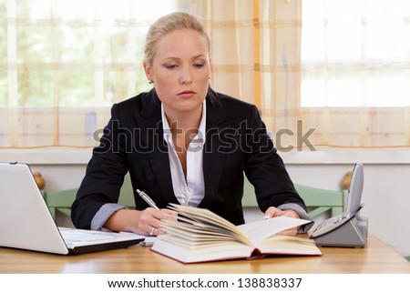successful young businesswoman sitting at desk with laptop computer and fracture