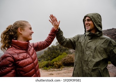 Successful Young Fit Couple High Five After Long Distance Trail Run On Mountains In Rain Cloudy Weather