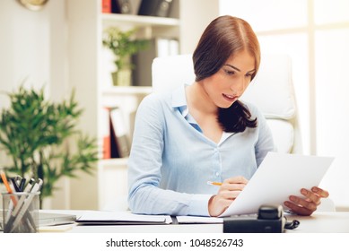 Successful young woman in the office brainstorming over business report. - Shutterstock ID 1048526743