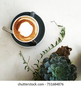 Succulent And Coffee Latte Flatlay, On A White Marble Background. Table Scene In A Cafe.