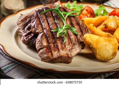 Succulent Portions Of Grilled Fillet Mignon Served With Baked Potatoes On A Plate