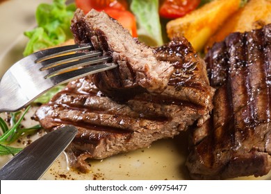 Succulent Portions Of Grilled Fillet Mignon Served With Baked Potatoes On A Plate