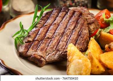 Succulent Portions Of Grilled Fillet Mignon Served With Baked Potatoes On A Plate