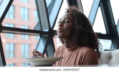 Such delicious tasty filling food. Close-up of a curly-haired beautiful woman tasting food in a new restaurant. - Powered by Shutterstock