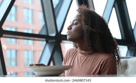 Such delicious tasty filling food. Close-up of a curly-haired beautiful woman tasting food in a new restaurant. - Powered by Shutterstock