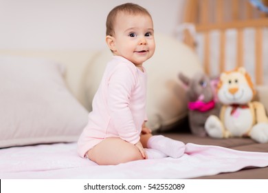 Such a happy little baby girl / Beautiful cute soft baby girl sitting on bed