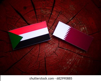 Sudan flag with Qatari flag on a tree stump isolated - Shutterstock ID 682990885