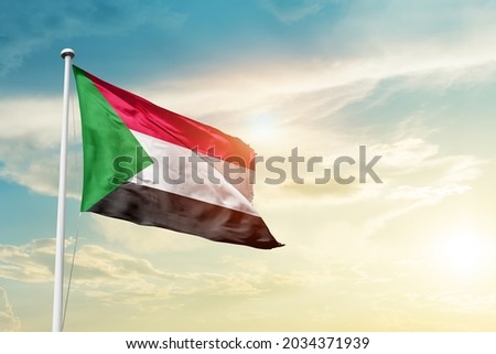 Sudan national flag waving in beautiful clouds.