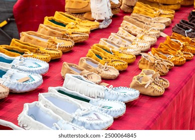 Suede leather moccasins. Pow Wow powwow vendor stall artisan display. Handmade handicraft. Indigenous First Nations Native American Indian traditional footwear. Beadwork fringe fringed. Culture pride. - Powered by Shutterstock