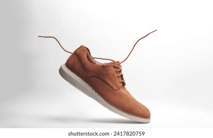 Suede shoes with flying laces on a white background