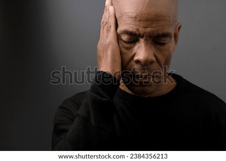 suffering from deafness and hearing loss on grey black background with people stock image stock photo