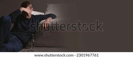 Suffering from hangover. Man with alcoholic drink on floor indoors, space for text. Banner design