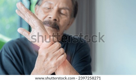 Suffering from pain and rheumatism. Closeup elderly, senior old man looking miserable in great excruciating hand ache painful wrist. Selective focus.