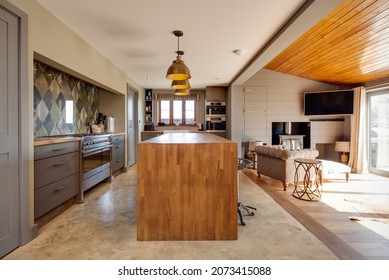 Suffolk, England - March 2018: Home Interior Kitchen Family Room Showing Breakfast Bar With Stools And Seatinga Area In Front Of Wood Burning Stove.