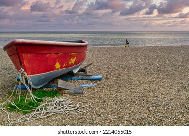 Suffolk, UK - 05.17.2021:Red Fishing Boat And Lone Fisherman On The Beach