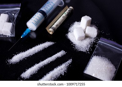 Sugar Addict. Addiction Of Sweets And Fast Carbohydrates. Lines Of White Sugar And A Dollar Curled Into A Tube Like A Line Of Cocaine. Dark Background