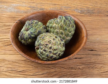 Sugar apples or custard apples in a bowl over wooden table.