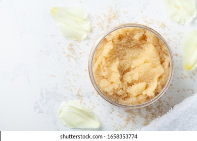 Sugar Body Scrub In Glass Jar On White Stone Table. Homemade Cosmetic For Spa.