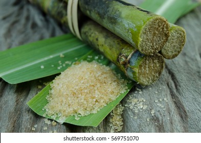 Sugar And Sugar Cane On Leaf And Wooden Background