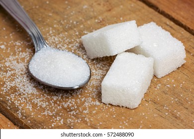 Sugar Cube In The Spoon On Wood Background