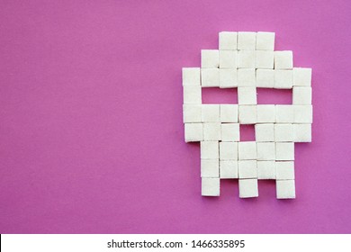 Sugar Cubes Laid Out In Shape Of Skull On Purple Background. Sugar Is White Death. Diabetes, Sugar Disease, Unhealthy Food, Diet Concept. Copy Space