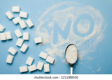 Sugar Cubes, Spoon And Letters NO On The Pastel Blue Background. Concept Of Sweet Drinks, Diet, Diebetes, Refined Sugar Free. Top View Minimal Flat Lay