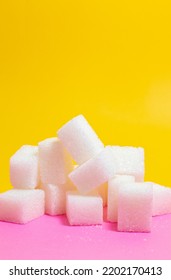 Sugar Cubes, Stack Of Sugar Cubes Isolated On Yellow And Pink Background. Unhealthy Sweet Food Idea Concept. Vertical Photo. No People, Nobody.