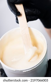 Sugar Depilation. Sugar Paste Dripping From A Wooden Spatula Into A Jar