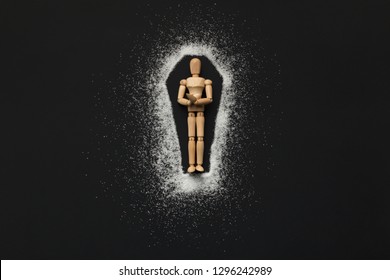 Sugar Diabetes Addiction Leads To Death. Wooden Mannequin In Coffin Made Of Sugar On Black Background, Top View