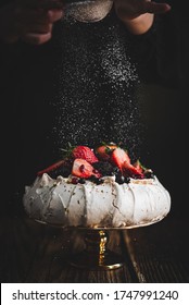Sugar dropping on fruity pavlova cake - Shutterstock ID 1747991240