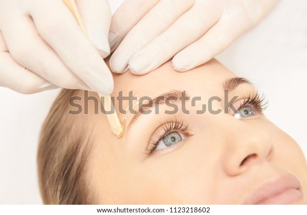 Sugar hair removal\
from woman body. Wax epilation spa procedure. Procedure beautician\
female. Eyebrow.