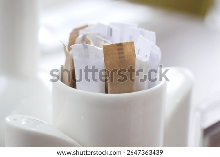 Sugar packets in a container at a dining table