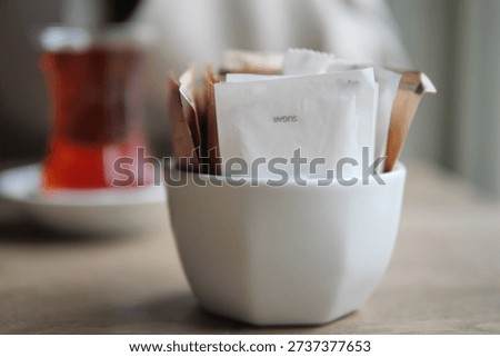 Sugar packets and tea at a table in a cafe
