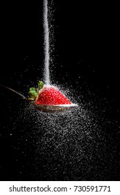 Sugar Pouring Over Strawberry On Spoon Isolated On Black Background