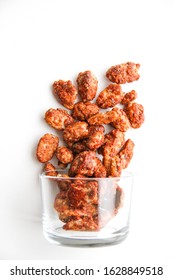 Sugar roasted pecan nuts (caramelized, praline nuts) in a glass on a white background, top view