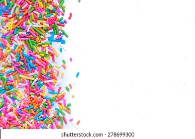 Sugar sprinkle dots, decoration for cake and bakery, a lot of sprinkles in a bucket on white wooden board background