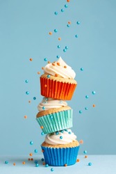 Sugar Sprinkles Falling On Stack Of Colorful Cupcakes