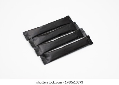 Sugar sticks on a white background. Sugar sticks without logo. Craft paper sugar bags. Sugar bags made of black paper. Mockup for applying a logo.