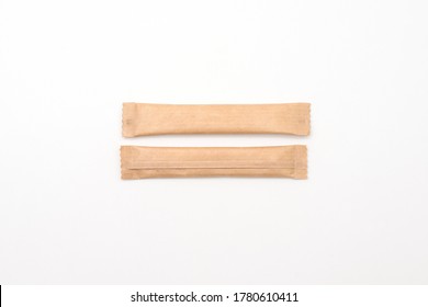 Sugar Sticks On A White Background. Sugar Sticks Without Logo. Craft Paper Sugar Bags. Sugar Bags Made Of Black Paper. Mockup For Applying A Logo.