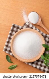 Sugar Substitute Sweetener In A Dish With Fresh Stevia Leaves And Spoon On Wooden Table. Top View.