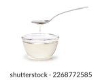 Sugar syrup in glass bowl and spoon isolated on white background. 