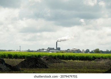 A Sugarcane Mill Emitting Smoke From Its Chimney Under A Stormy Sky